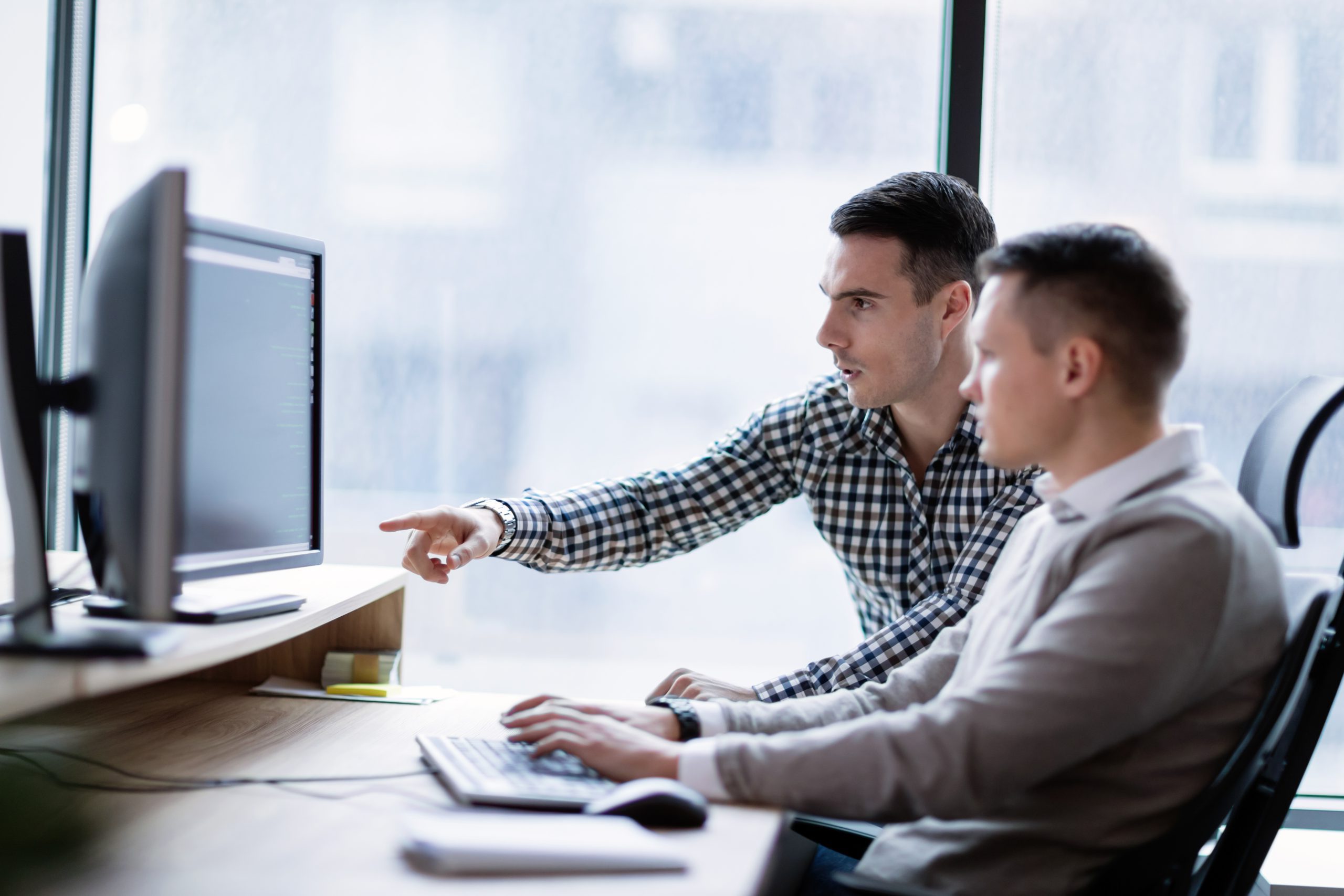 Twee mensen werken samen achter en computer. Ter illustratie van het CCV-dossier Cybercrime.