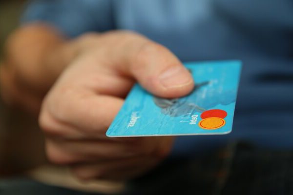 Een persoon overhandigt zijn pinpas. Ter illustratie van het begrip geldezels in het CCV-dossier Cybercrime.