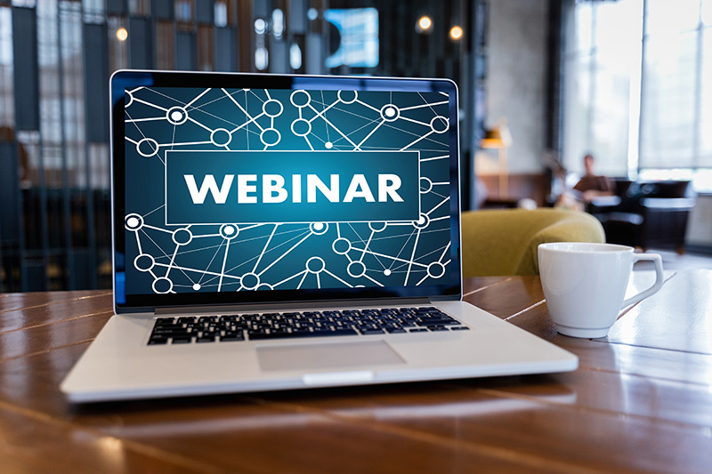 laptop op tafel met op scherm het woord 'webinar'