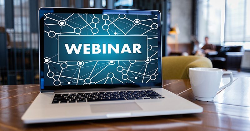 laptop op tafel met op scherm het woord 'webinar'