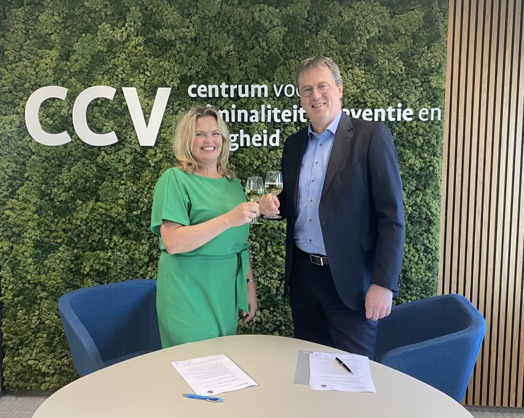 Evelien Bras van stichting CYRA en Patrick van den Brink van het CCV proosten op de samenwerking op het gebied van cybersecurity.