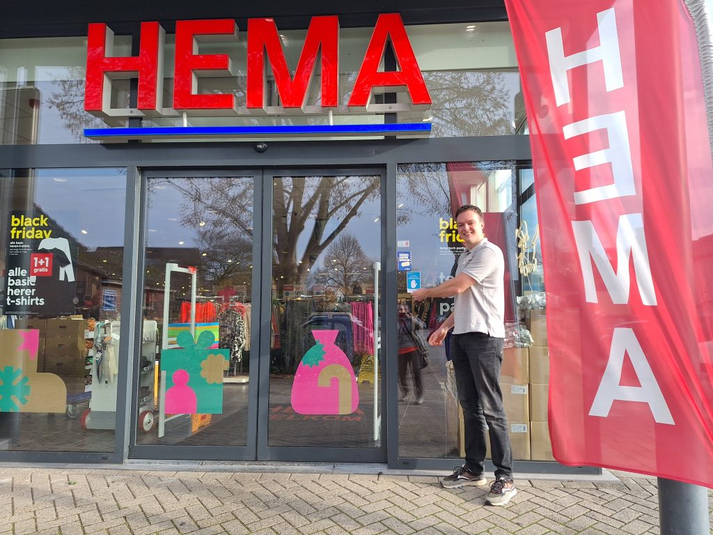 Jordy Heij plakt de collectief winkelverbod sticker op de Hema in Bennekom.