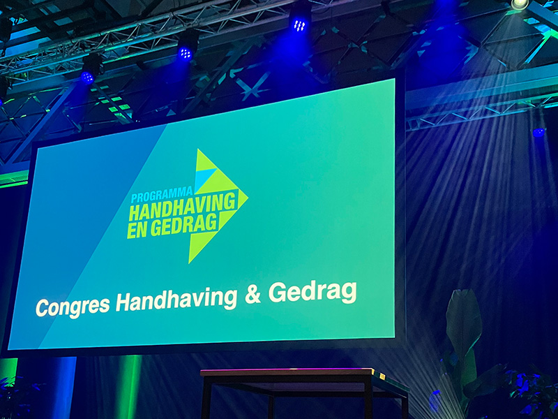 Beginscherm tijdens congres van Programma Handhaving en gedrag met daarop het logo.