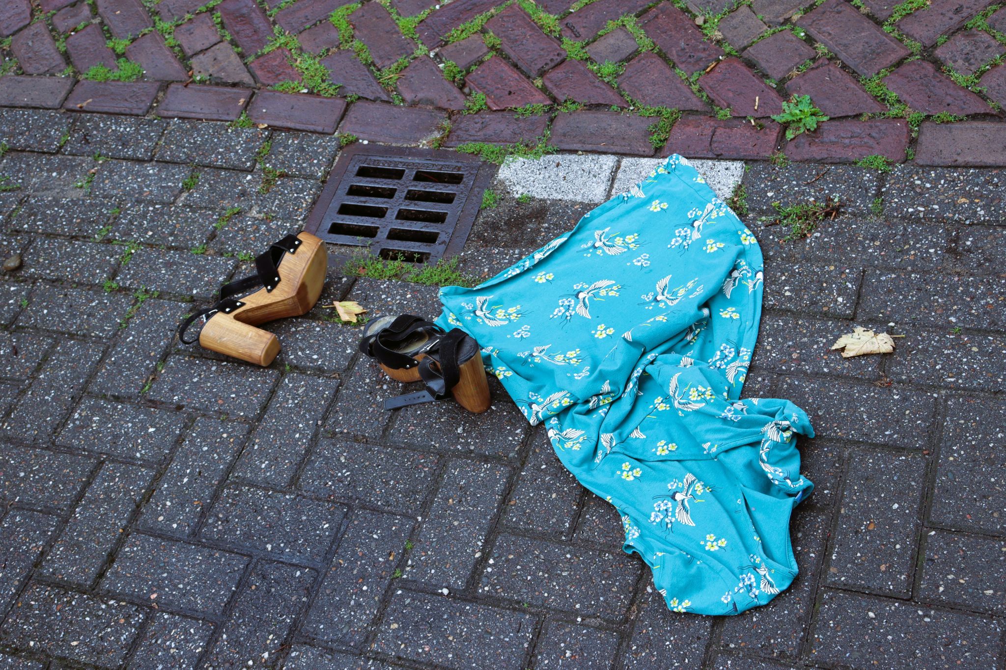 Vrouwenschoenen en sjaal liggen achtergelaten op straat.