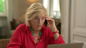 Oudere vrouw aan de telefoon.