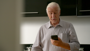 Oudere man op telefoon.