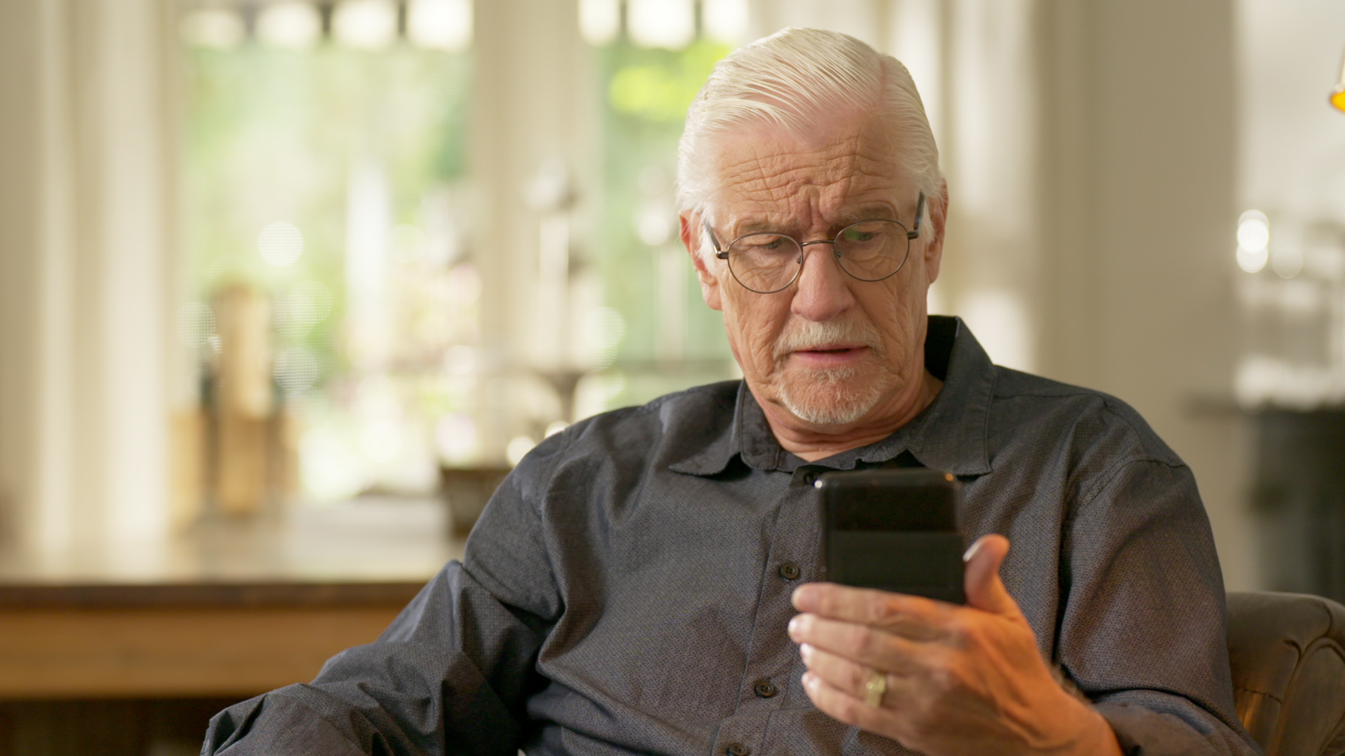 Oudere man op telefoon.