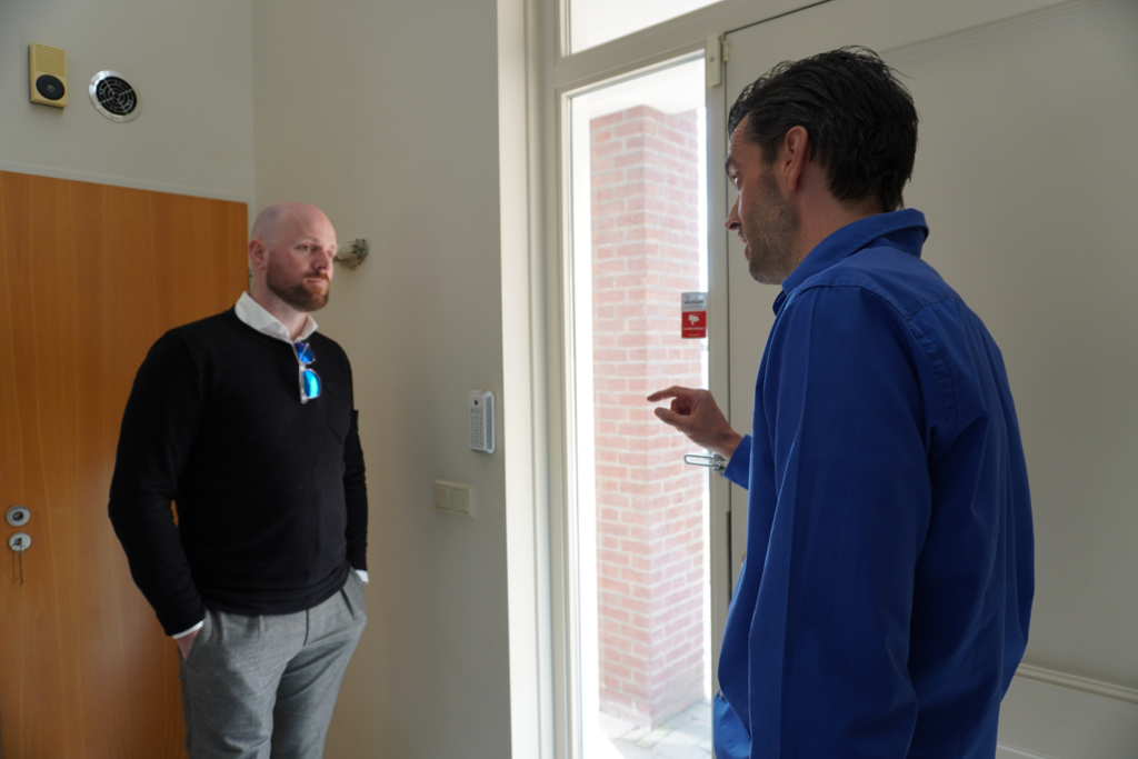Thijs Spanbroek (rechts) vertelt de burgemeester dat een intercom bij de voordeur ontbreekt.