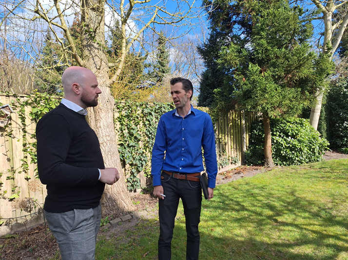 Thijs Spanbroek van het CCV loopt met burgemeester Ryan Palmen door de tuin van zijn woning.
