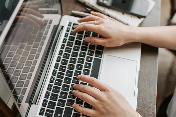 Handen op een laptop.