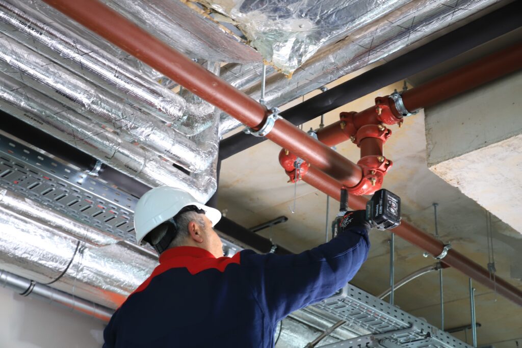 Monteur werkt aan watervoerende vastopgestelde brandbeheersings- en brandblussysteem (VBB-systemen).