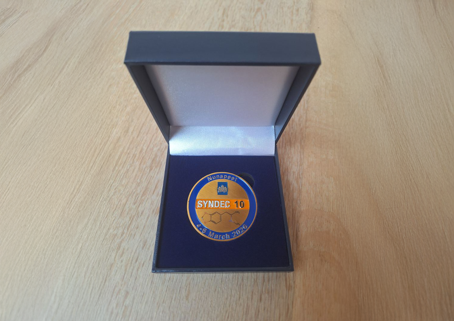 Van 4 tot en met 6 maart 2026 kwamen in Nunspeet ongeveer 230 experts uit de hele wereld bijeen voor SYNDEC 10, Ze kregen een deelnamemunt en die staat op deze foto.